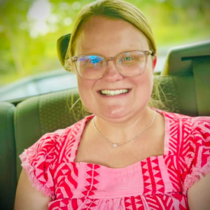 A photo of Shelbi Davenport wearing a pink shirt and smiling.